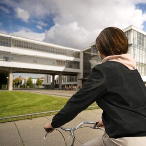 Radfahrerin vor dem Bauhausgebäude Dessau