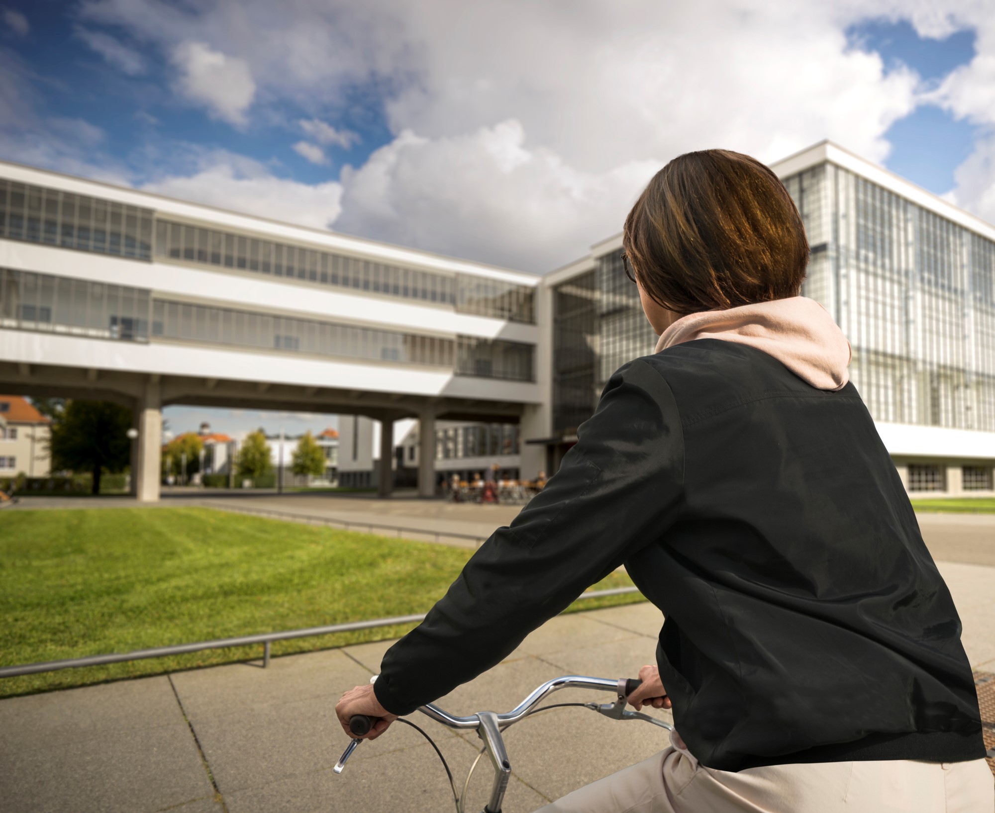 Radfahrerin vor dem Bauhausgebäude Dessau