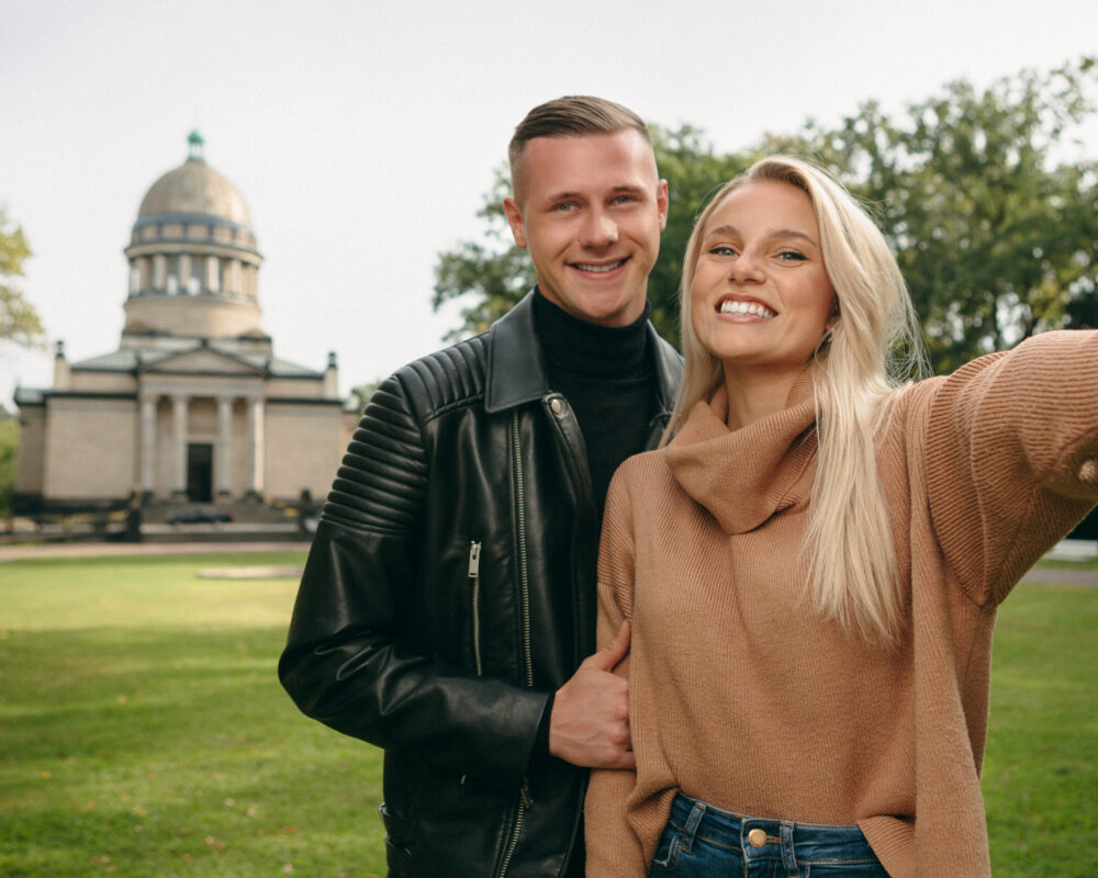 Zu sehen ist ein Pärchen die ein Selfie vor dem Mausoleum in Dessau machen.